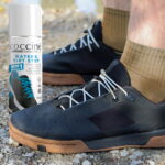 Impregnat do butów z membraną Coccine obok męskich nóg w sportowym obuwiu